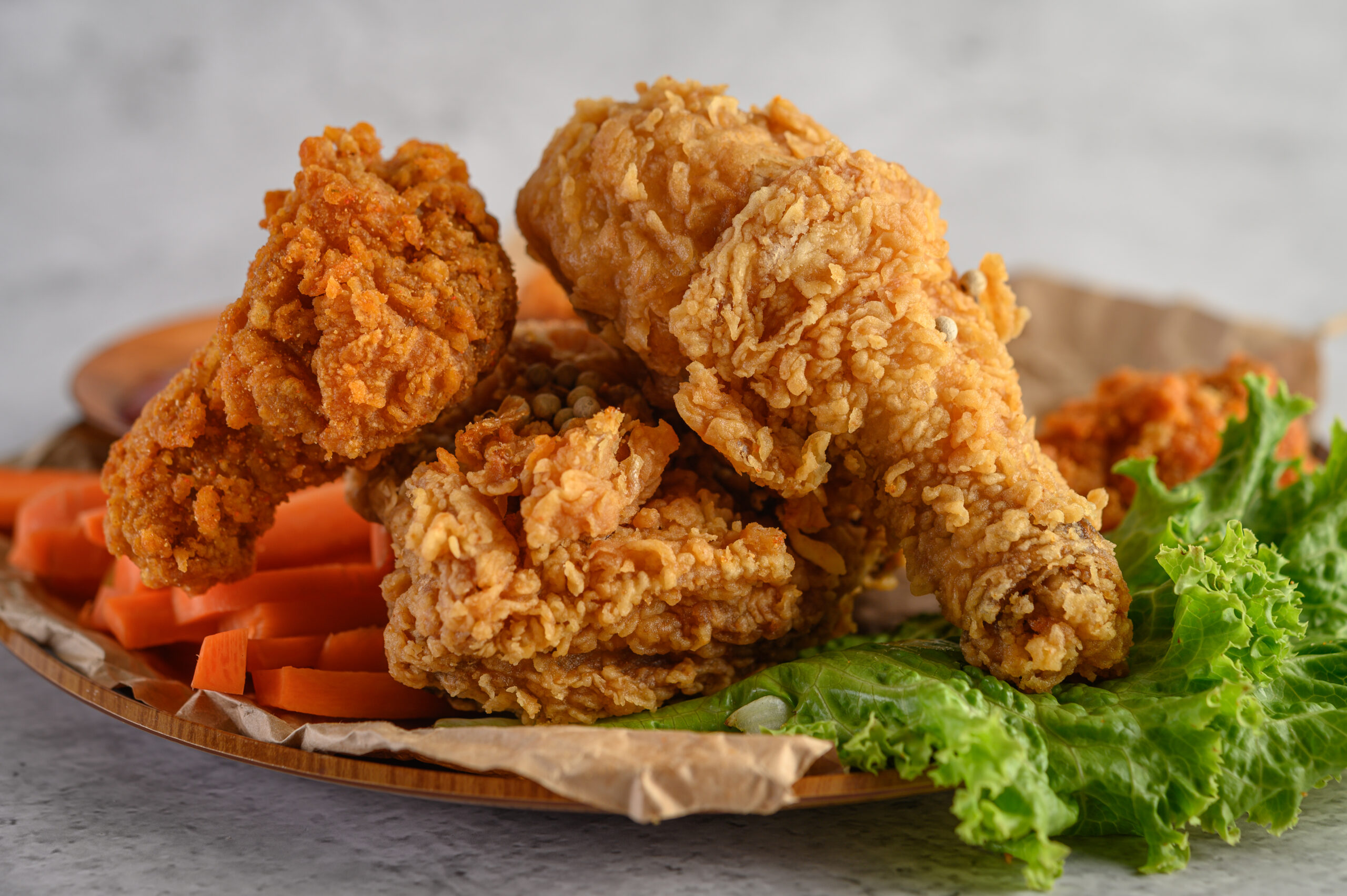 Crispy fried chicken on a plate with salad and carrot, Selective